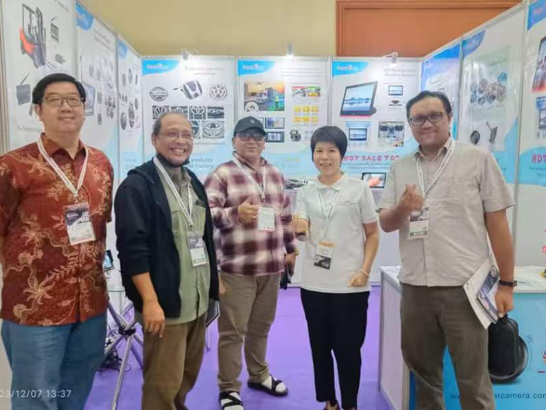 SuperPower representative with visitors at an automotive electronics exhibition booth