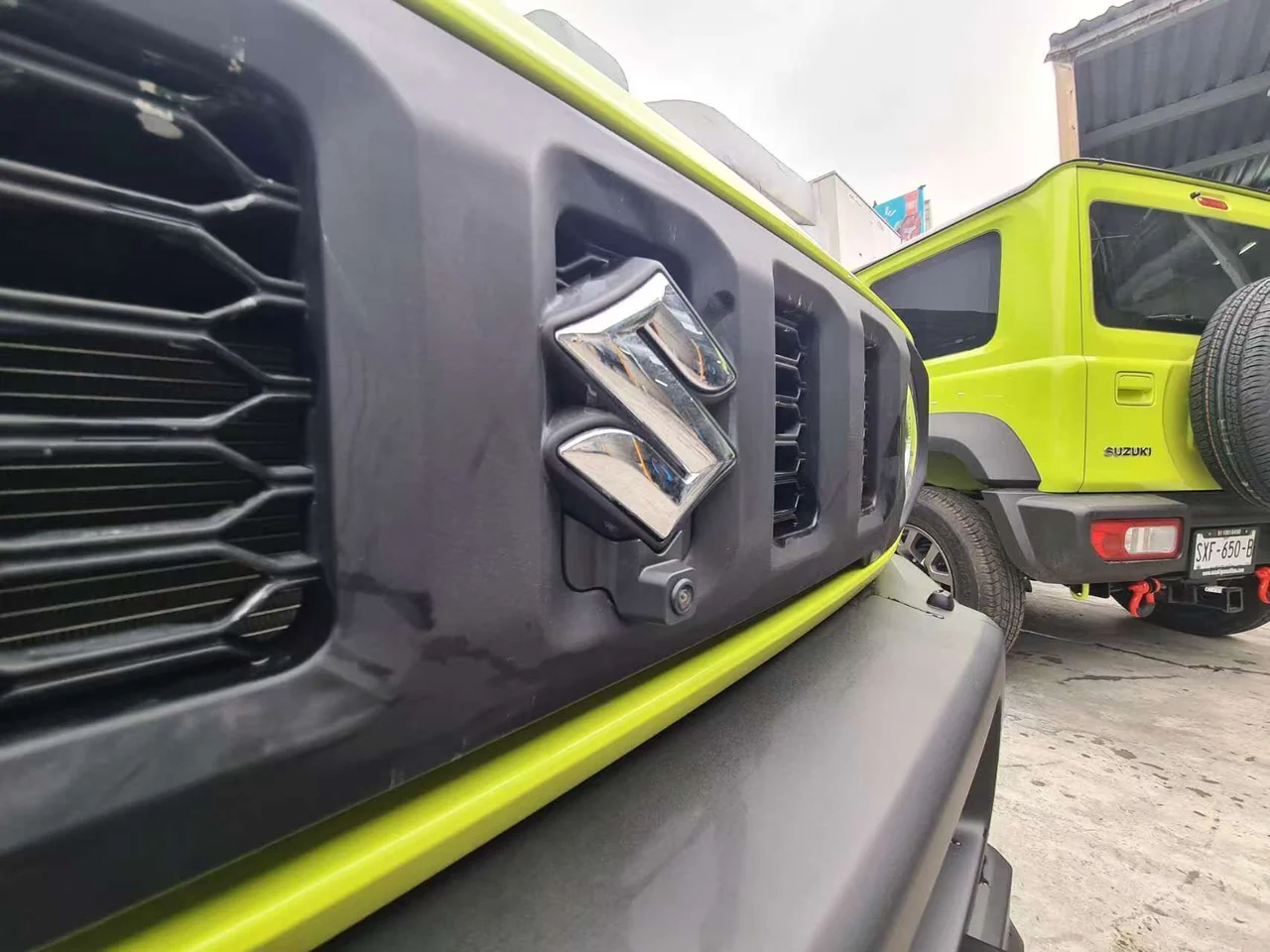 Customer-supplied photo of a front camera below the grille badge of a lime-green off-road vehicle