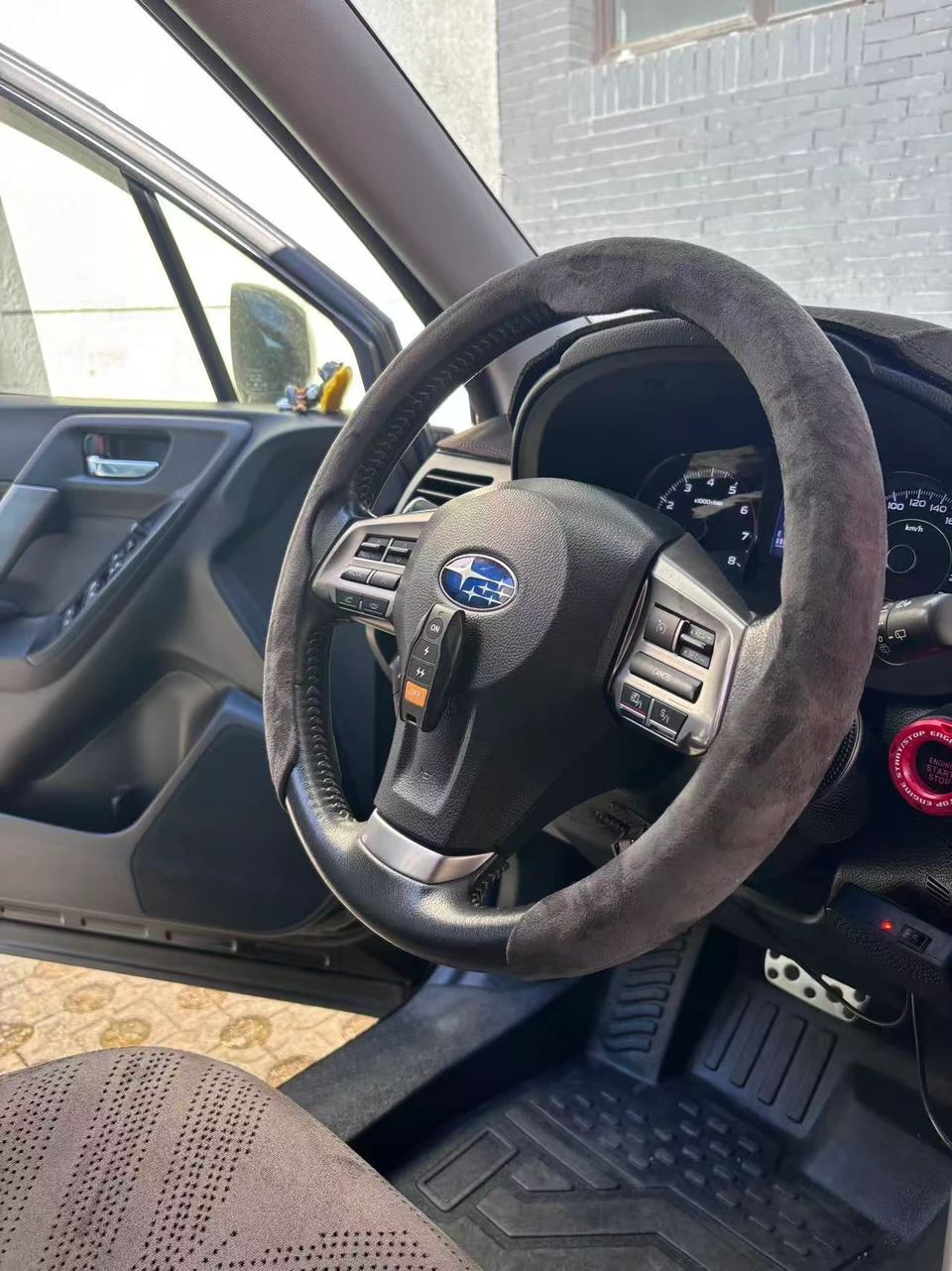 Heated steering wheel cover on a Subaru wheel with separate visible control