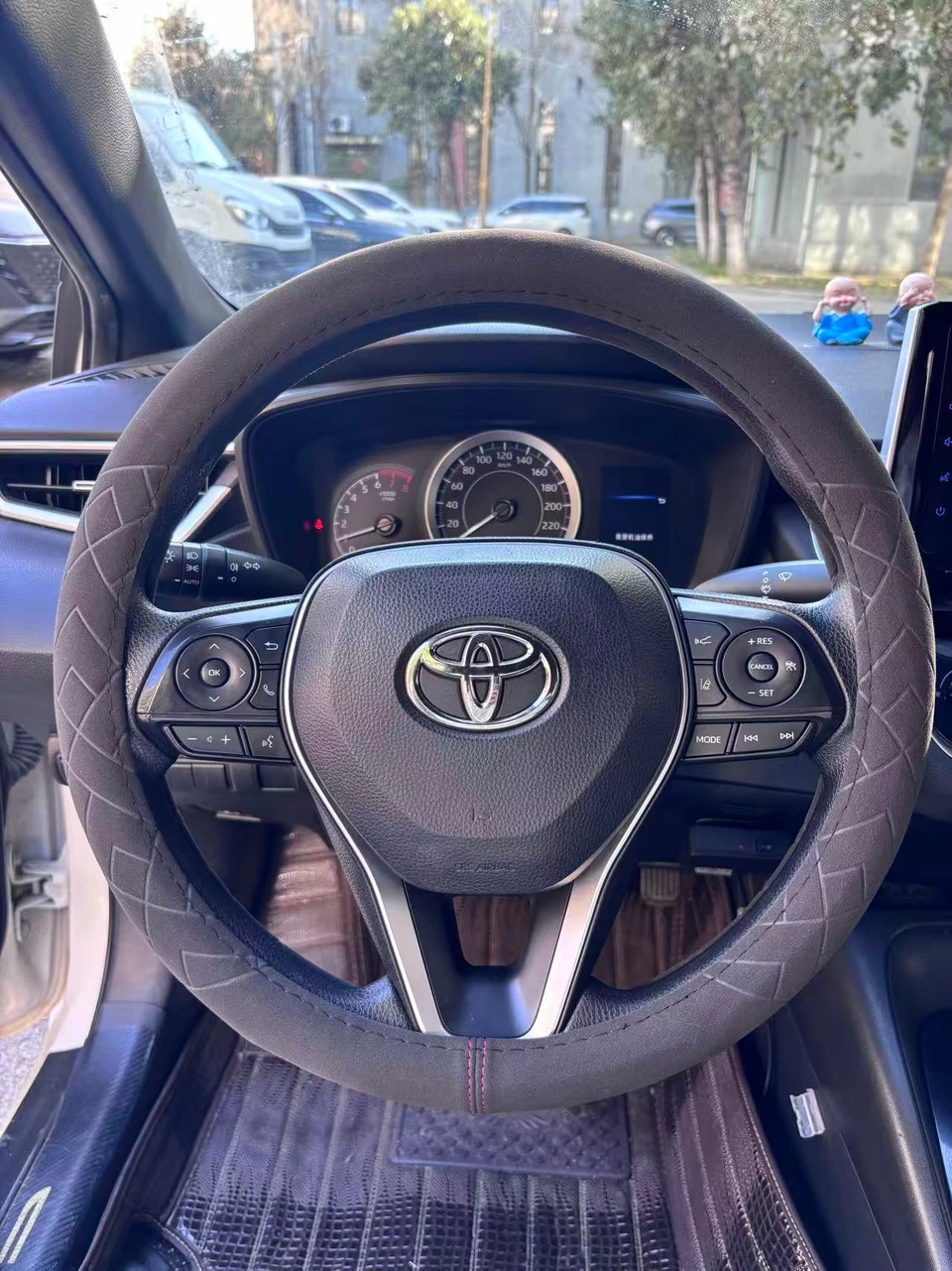 Grey heated steering wheel cover installed on a Toyota steering wheel